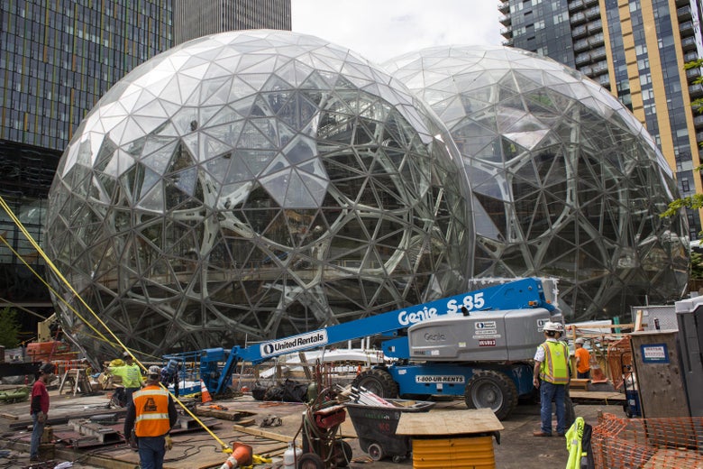 SEATTLE, WA - JUNE 16: Workers surround the signature glass spheres under construction at the Amazon corporate headquarters on June 16, 2017 in Seattle, Washington. Amazon announced that it will buy Whole Foods Market, Inc. for over $13 billion dollars. (Photo by David Ryder/Getty Images)